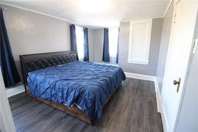 bedroom with crown molding, dark hardwood / wood-style flooring, and a textured ceiling