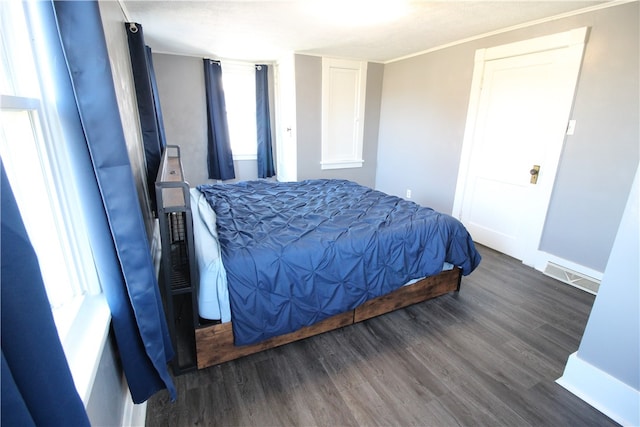 bedroom featuring ornamental molding, multiple windows, and dark wood-type flooring