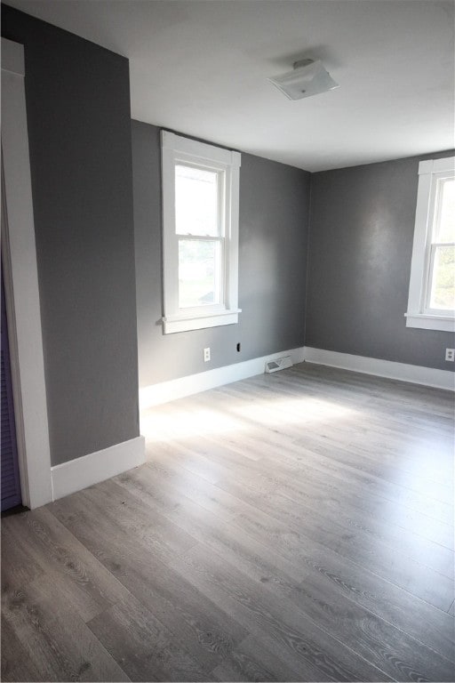 unfurnished room with hardwood / wood-style floors and a healthy amount of sunlight