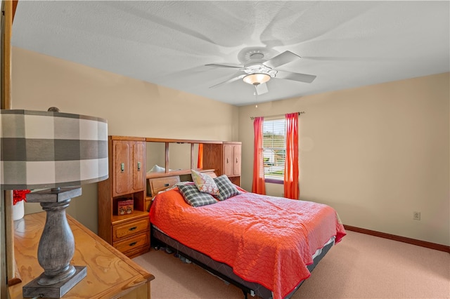 bedroom with a textured ceiling, carpet flooring, and ceiling fan