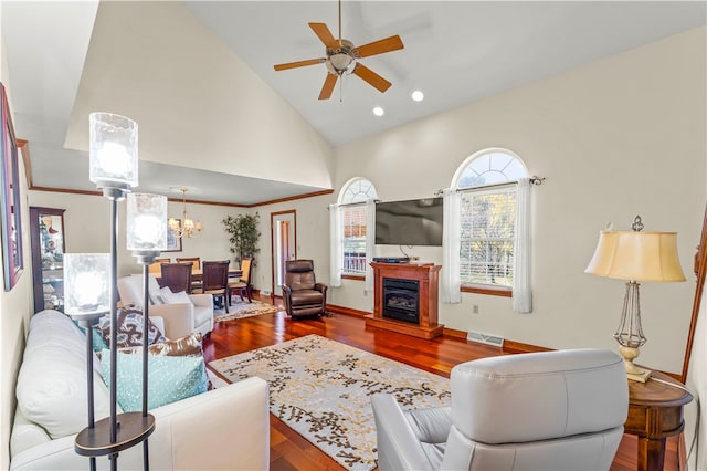 living room with high vaulted ceiling, ceiling fan with notable chandelier, and wood-type flooring