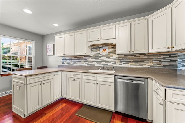 kitchen featuring dark wood-type flooring, dishwasher, kitchen peninsula, sink, and tasteful backsplash