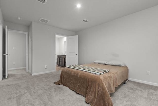 bedroom featuring light colored carpet and ensuite bathroom