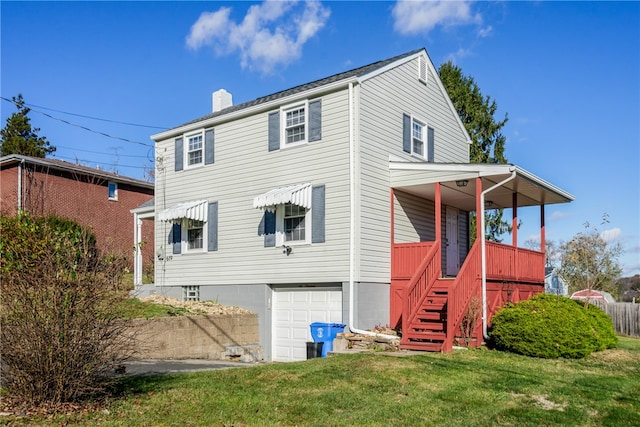 rear view of property with a garage and a yard