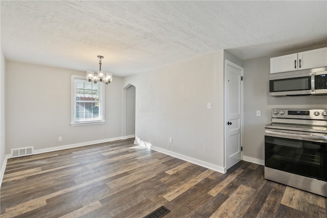 kitchen featuring appliances with stainless steel finishes, a textured ceiling, dark hardwood / wood-style floors, and white cabinets