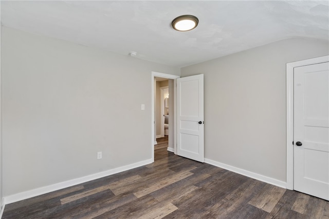 empty room featuring dark hardwood / wood-style floors and vaulted ceiling