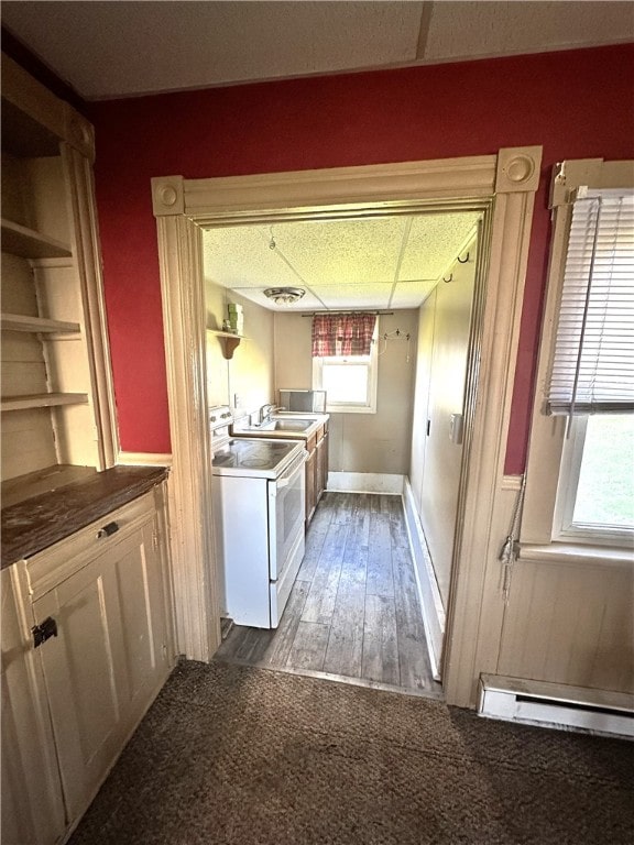 kitchen with white electric range oven, dark hardwood / wood-style floors, and a baseboard heating unit