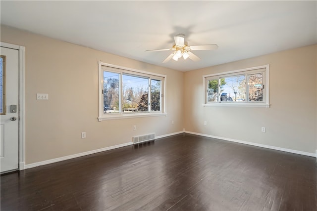 spare room featuring dark wood-type flooring and ceiling fan