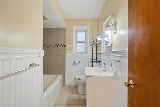 bathroom featuring a bathing tub, tile patterned flooring, vanity, and toilet