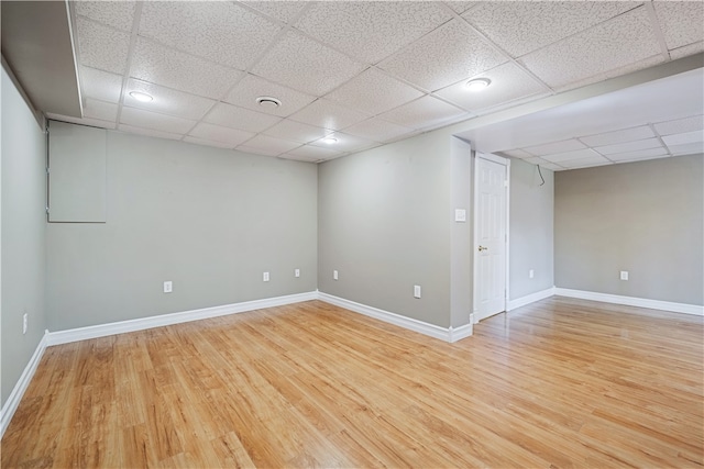 spare room with hardwood / wood-style flooring and a drop ceiling