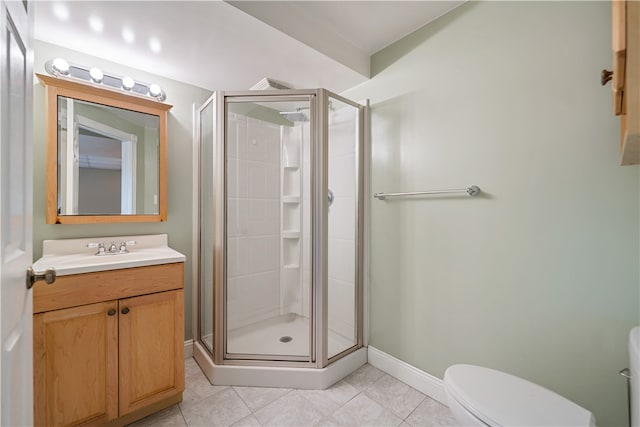 bathroom with vanity, a shower with shower door, tile patterned floors, and toilet