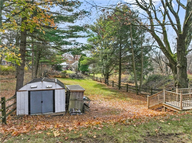 view of yard with a wooden deck and a storage unit