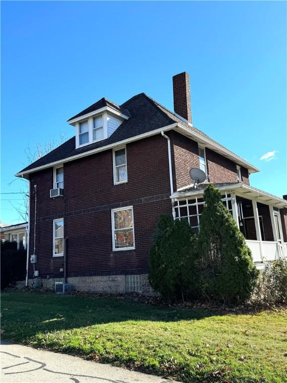 1300 Sycamore St, Connellsville, PA 15425 - view of side of home featuring a chimney, a yard, brick siding, a sunroom, and cooling unit