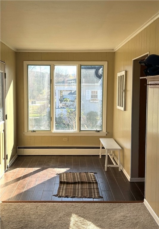 unfurnished sunroom featuring a baseboard heating unit and plenty of natural light