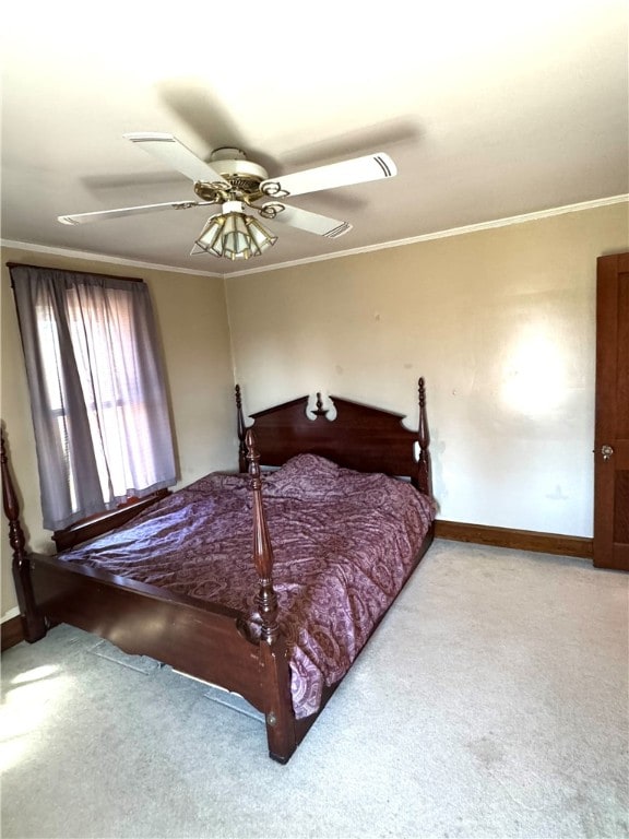 carpeted bedroom with ornamental molding and ceiling fan