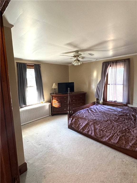 bedroom with radiator heating unit, carpet, and ceiling fan