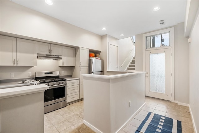 kitchen featuring appliances with stainless steel finishes, light tile patterned flooring, a center island, and gray cabinetry