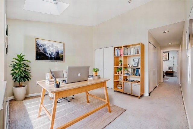 carpeted office space with a skylight