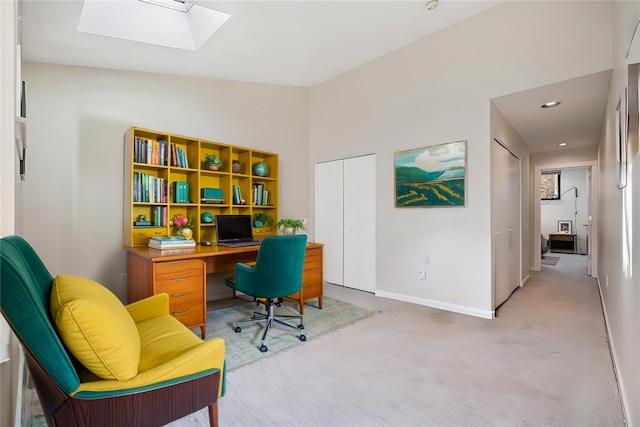 office space featuring light carpet and lofted ceiling with skylight