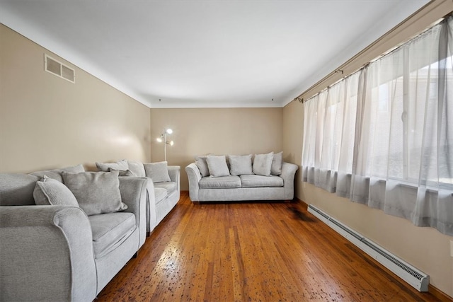 living room with baseboard heating and dark hardwood / wood-style floors