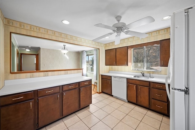 kitchen featuring light tile patterned floors, dark brown cabinets, sink, white appliances, and ceiling fan