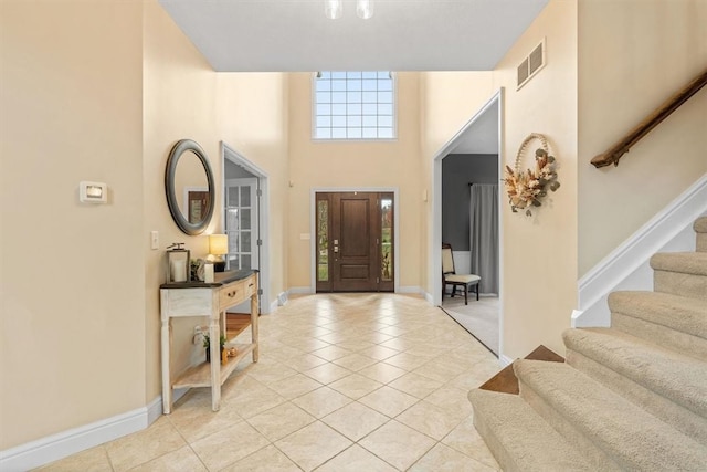 tiled foyer entrance with a towering ceiling