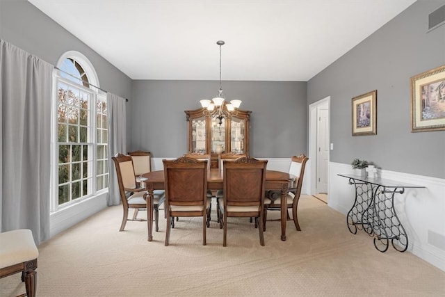 carpeted dining space featuring a chandelier