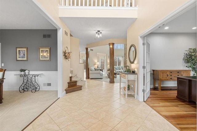 foyer entrance featuring ornate columns and light hardwood / wood-style flooring