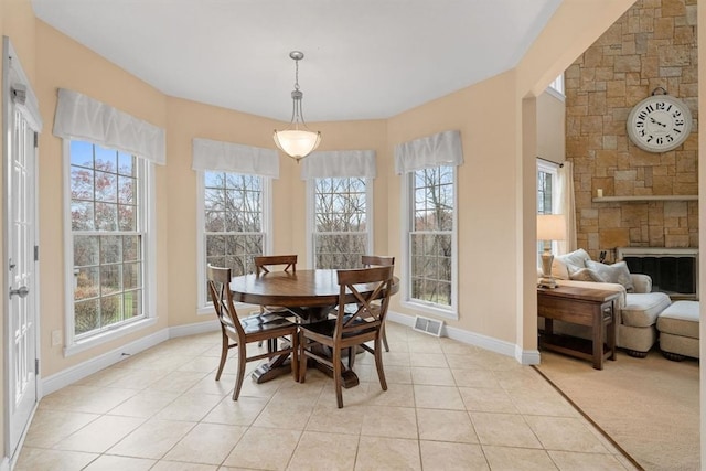 dining space featuring light tile patterned floors and a fireplace