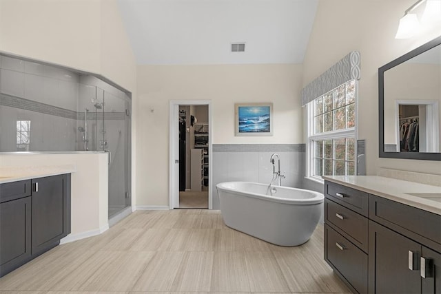 bathroom with vanity, independent shower and bath, and lofted ceiling