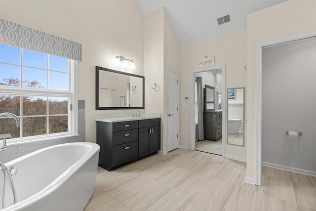 bathroom with vanity, a bathtub, and vaulted ceiling