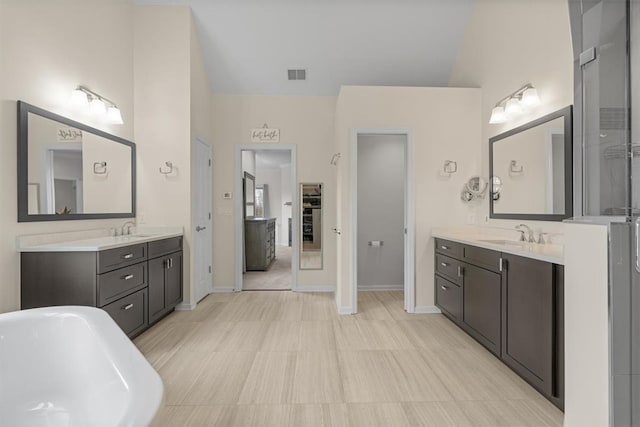 bathroom with vanity, a washtub, and lofted ceiling