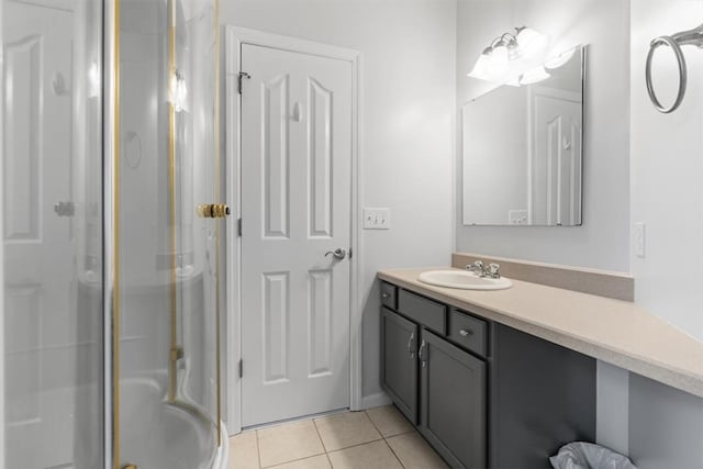 bathroom featuring vanity, a shower with door, and tile patterned flooring