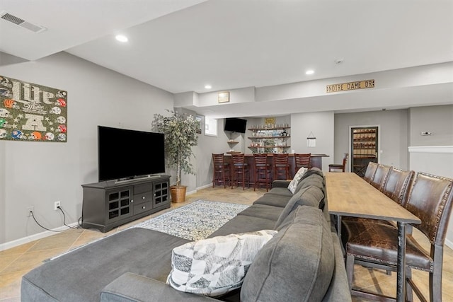 living room with bar area and light tile patterned floors