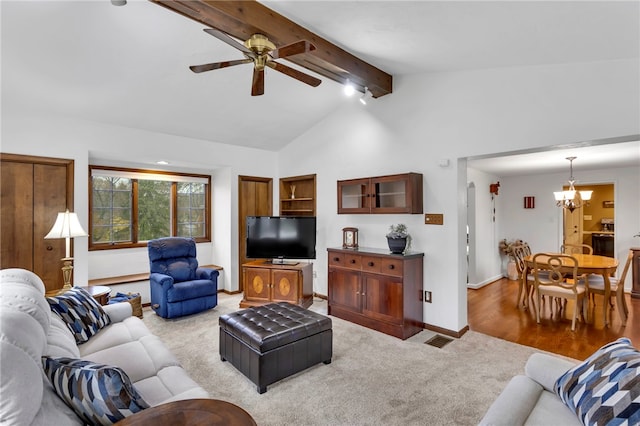 living room with beamed ceiling, high vaulted ceiling, ceiling fan with notable chandelier, and light wood-type flooring