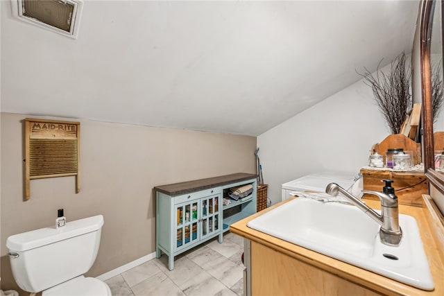 bathroom with vanity, toilet, and vaulted ceiling