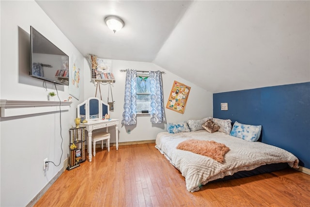 bedroom featuring hardwood / wood-style flooring and vaulted ceiling