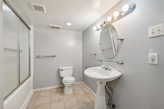 bathroom featuring tile patterned floors, combined bath / shower with glass door, and toilet