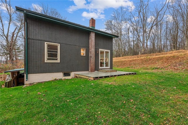 rear view of property with a deck and a lawn