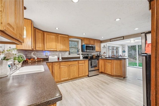 139 Willow Rd, Washington Twp Wml, PA 15613 - kitchen featuring appliances with stainless steel finishes, a sink, a peninsula, dark countertops, and decorative backsplash