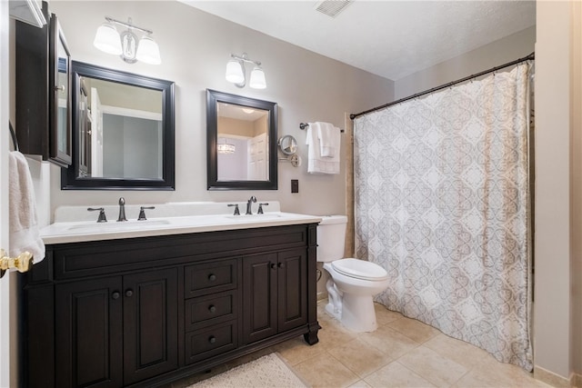 bathroom with vanity, tile patterned floors, a textured ceiling, and toilet