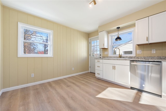 kitchen with stainless steel dishwasher, a healthy amount of sunlight, light hardwood / wood-style flooring, and white cabinetry