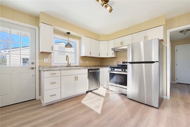 kitchen with white cabinetry, a wealth of natural light, stainless steel appliances, and light wood-type flooring