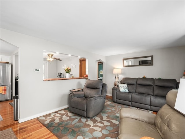 living room featuring light wood-type flooring and ceiling fan