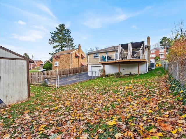 view of yard with central air condition unit and a wooden deck