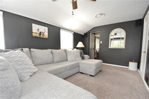 carpeted home theater with ceiling fan and vaulted ceiling