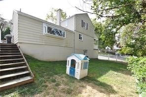 rear view of property featuring a lawn