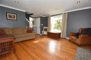 living room with hardwood / wood-style flooring and crown molding