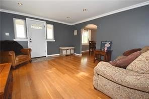 living room with wood-type flooring and ornamental molding