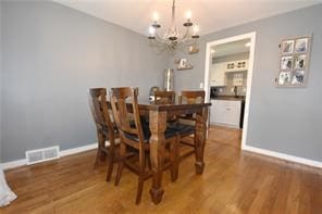 dining space with a chandelier and wood-type flooring